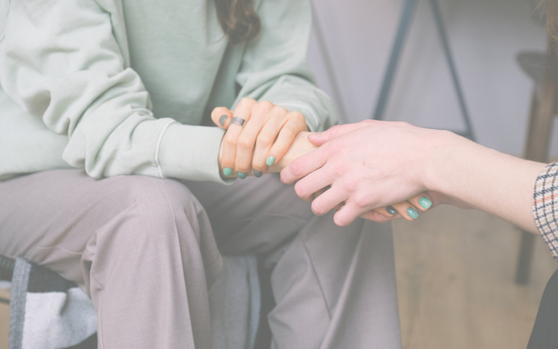 supportively holding a hand